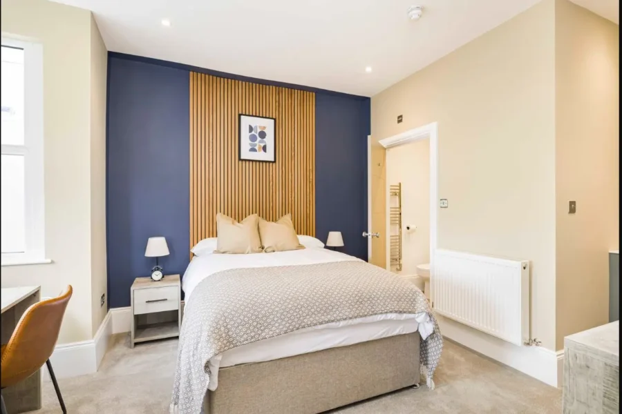 Furnished double bedroom with feature wall at 2 Essex Road