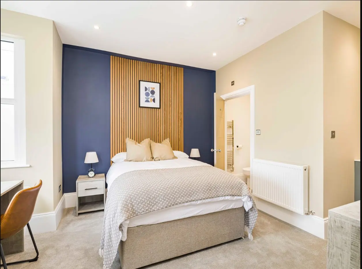 Furnished double bedroom with feature wall at 2 Essex Road