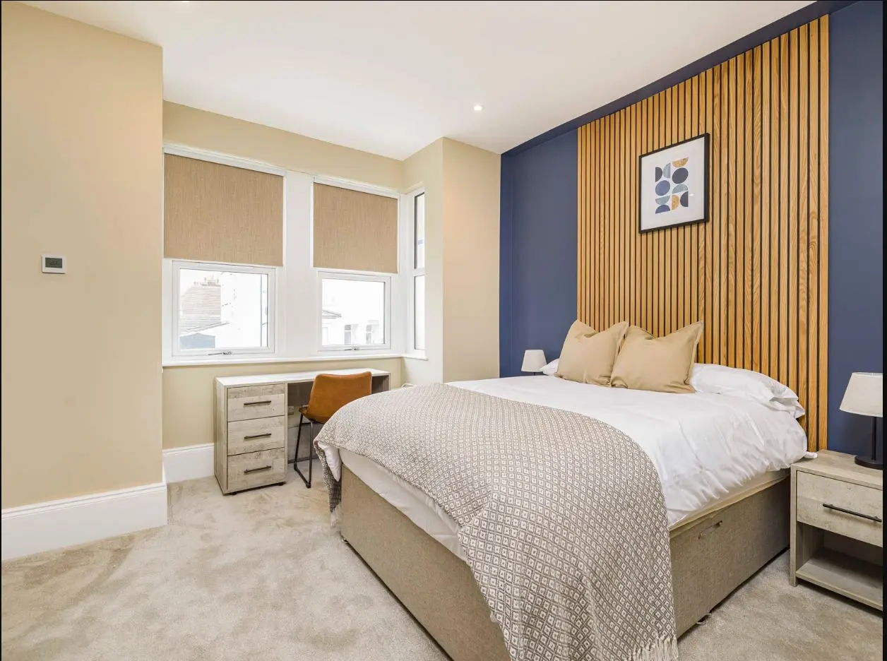 Double bedroom with desk and feature wall at 2 Essex Road